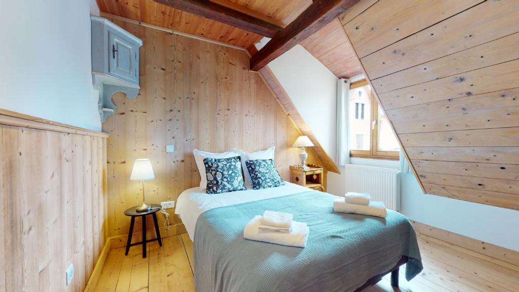 um quarto com uma cama grande e paredes de madeira em Les Appartements Manala - Turckheim em Turckheim