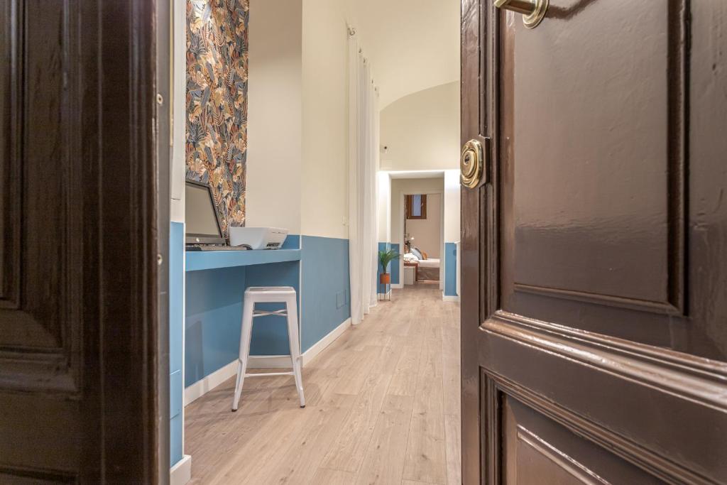 un corridoio con scrivania blu e sgabello di Vittoria Garden Suites a Roma