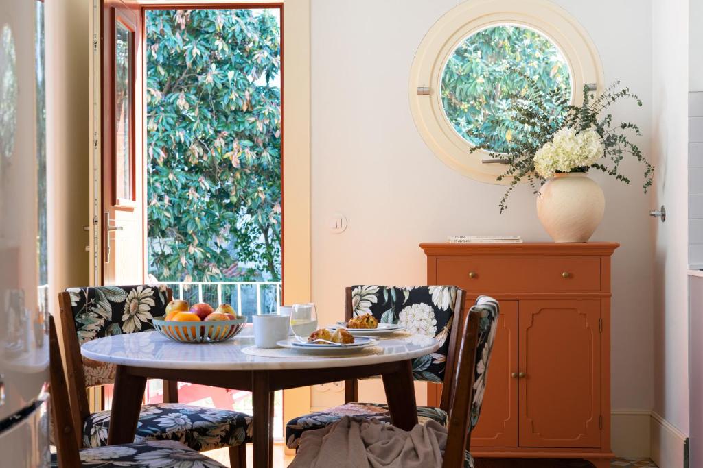 a dining room with a table with fruit on it at Entre Ruas Apartments in Coimbra