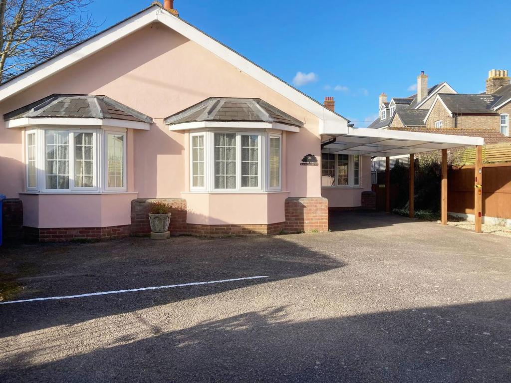 Casa rosa con ventanas blancas y entrada en Walnut Cottage en Long Melford