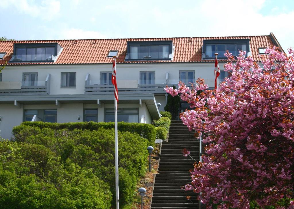 a staircase leading to a building with pink flowers at Vigen Apartments in Ebeltoft
