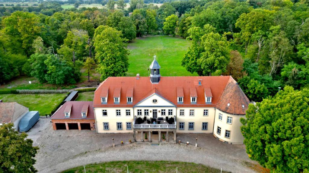 Hotel Schloss Grochwitz (garni) في Herzberg: اطلالة جوية على بيت ابيض كبير بسقف احمر