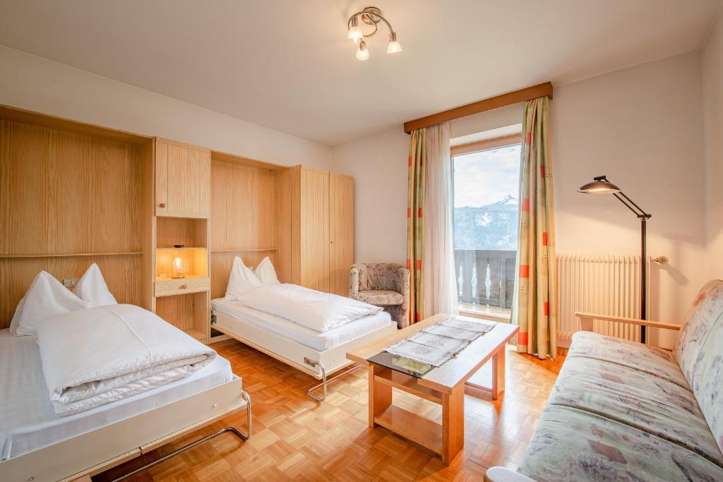 una camera d'albergo con due letti e una finestra di Garni-Residence Villa Paul a Nova Ponente