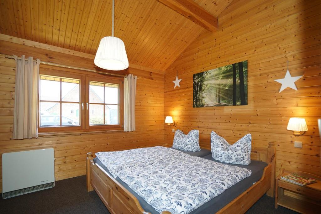 クックスハーフェンにあるFerienpark Harmsenの木造キャビン内のベッド1台が備わるベッドルーム1室を利用します。