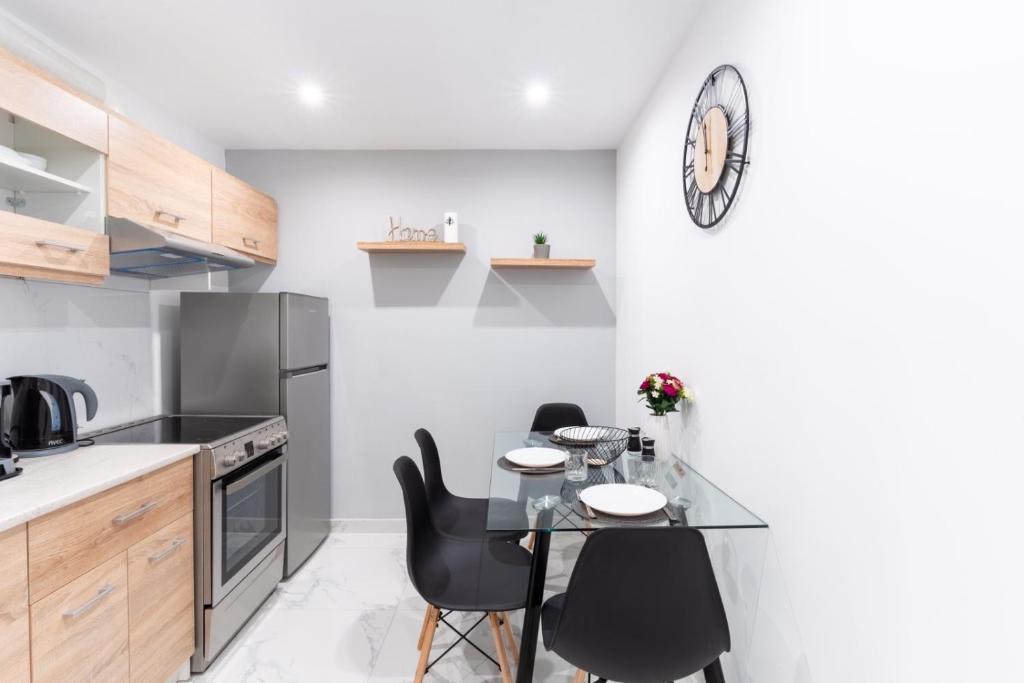 een keuken met een tafel en stoelen en een klok aan de muur bij elegant escapes 2 nea smyrni in Athene