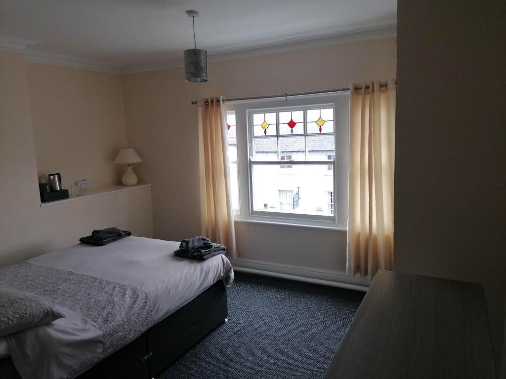 a bedroom with a bed and a window at The Queens Head in Ashby de la Zouch