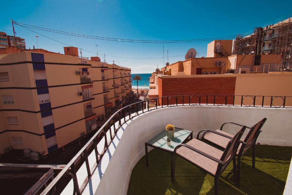 einen Balkon mit einem Tisch und Stühlen auf einem Sims in der Unterkunft COVESA III Centro Levante Beach in Benidorm