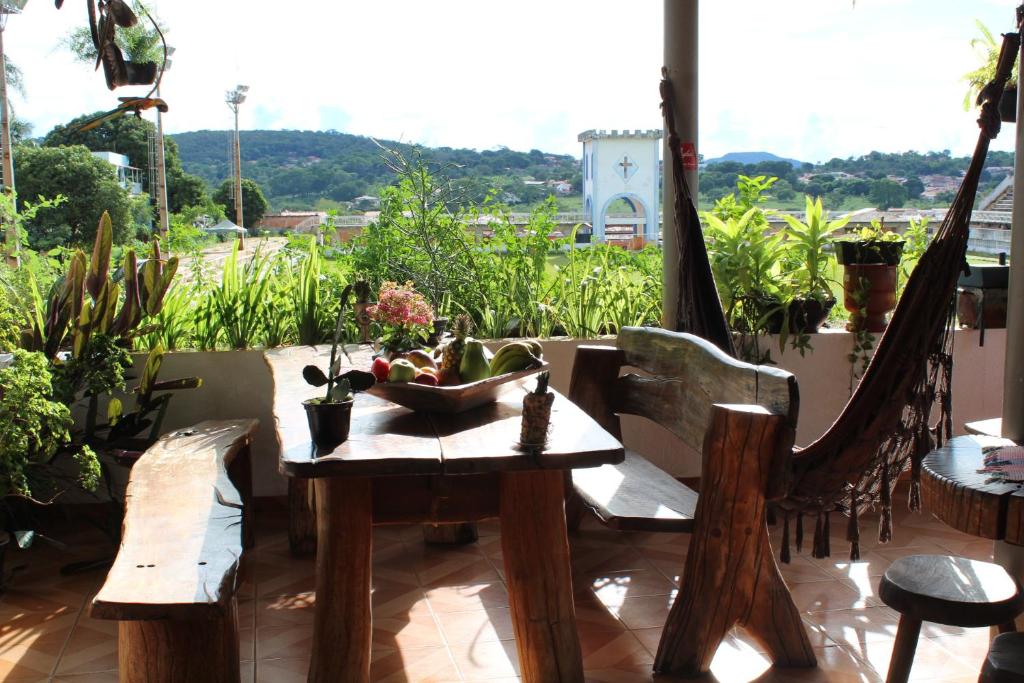 a table with chairs and a bowl of flowers on a patio at Pousada Torre dos Mouros in Pirenópolis