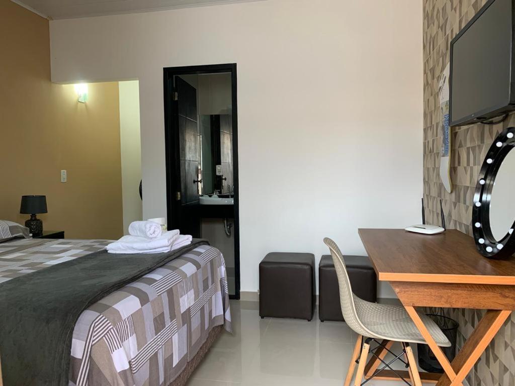 安格拉杜斯雷斯的住宿－Suíte 101- Espaço Praia Aptos，一间卧室配有一张床、一张桌子和一张桌子
