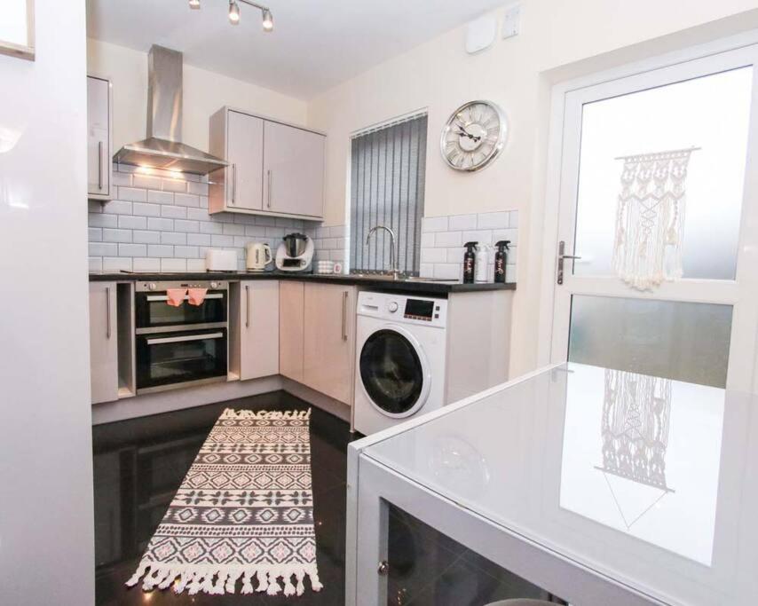 uma cozinha com máquina de lavar e secar roupa em No25-Luxe Living Guest House- 2 Bed-WIFI-Free Parking-City- Beach em Swansea