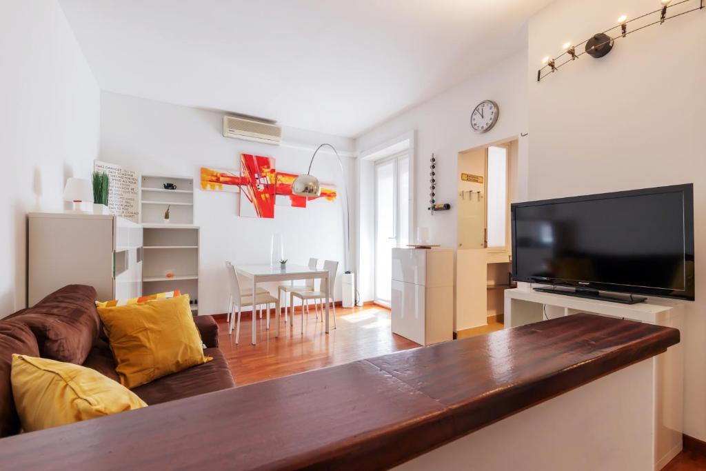 een woonkamer met een bank en een flatscreen-tv bij Terrace at 20 minutes from Duomo - HomeUnity in Milaan