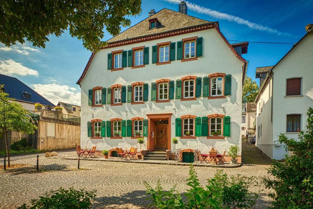 a large white building with green shuttered windows at NEU!!! Moselbleibe Uferallee in Bernkastel-Kues