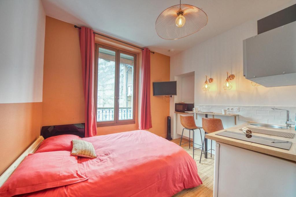 Cet appartement comprend une chambre avec un lit rouge et une cuisine. dans l'établissement La Casa Roja - Championnet / Caserne de Bonne, à Grenoble