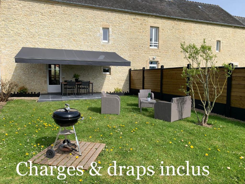 a bbq grill in the yard of a house at Gîte avec jardin à 1,5 km des plages du débarquement in Tracy-sur-Mer