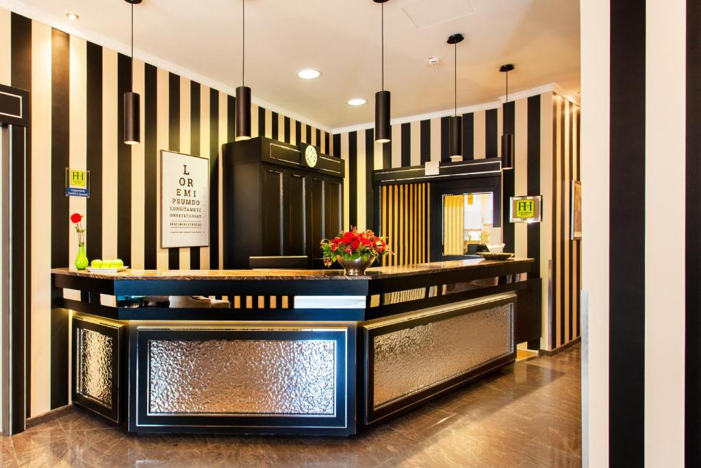 a lobby with black and white striped walls and a counter at The Domicil Hotel Frankfurt City in Frankfurt