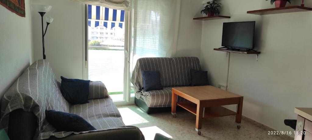 een woonkamer met een bank, een tafel en een tv bij Apartamento Luminoso el Morche in Morche