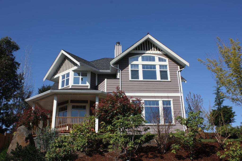 une maison avec des fenêtres blanches et un toit dans l'établissement Eaglenest Manor Cowichan, à Duncan