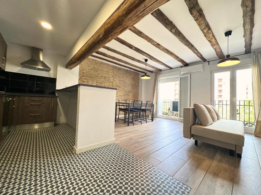 a kitchen and living room with a couch and a table at Dos Torres Rivendel - Vistas a la Basílica del Pilar in Zaragoza