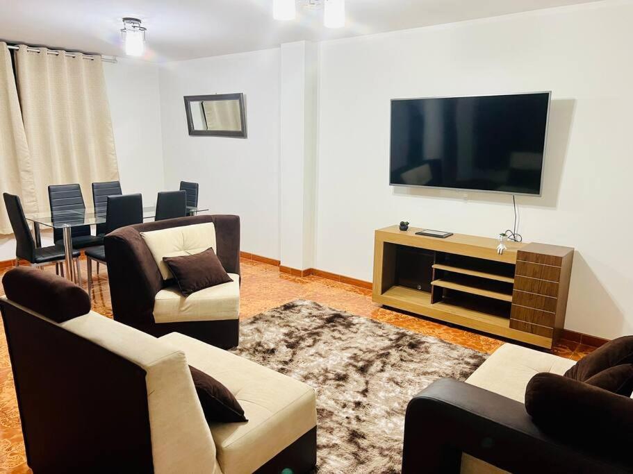 a living room with couches and a flat screen tv at Departamento Amplio Pérez Gamboa in Tacna