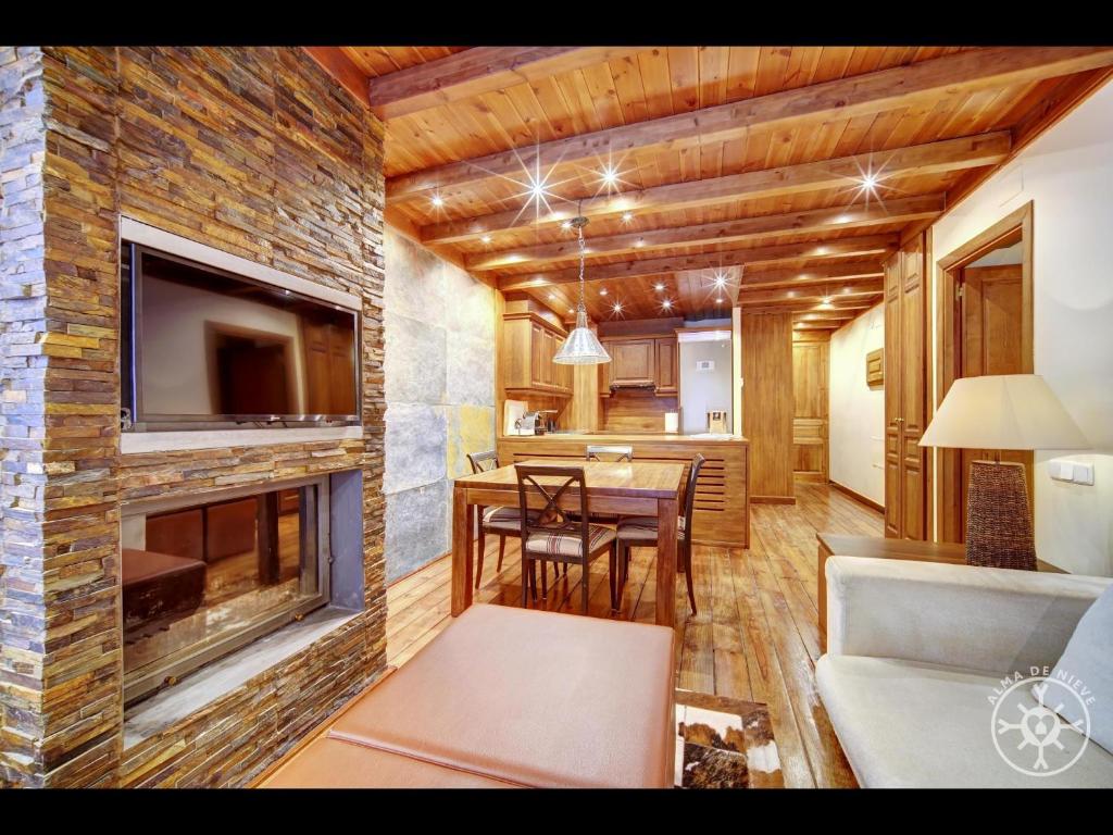 sala de estar con chimenea y comedor en BACIVER de Alma de Nieve, en Naut Aran (Alto Arán)
