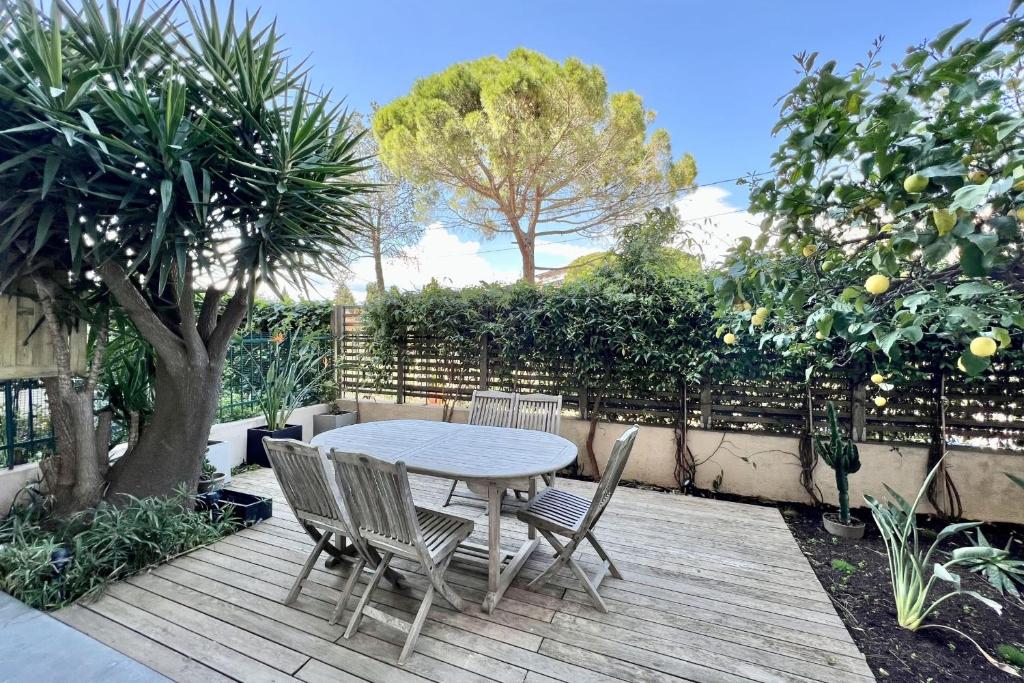 a table and chairs sitting on a wooden deck at Superb luxury Flat garden pool tennis in Le Cannet