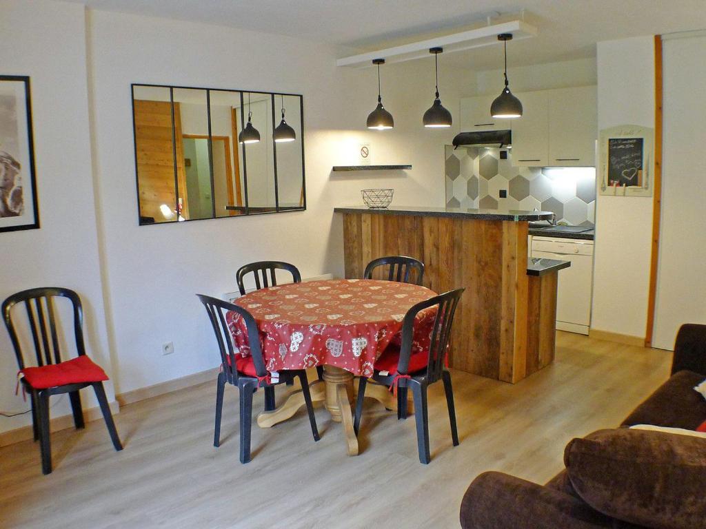 une salle à manger avec une table et des chaises et une cuisine dans l'établissement Appartement Confortable avec Piscines, Terrasse et Parking à Samoëns - FR-1-629-100, à Samoëns