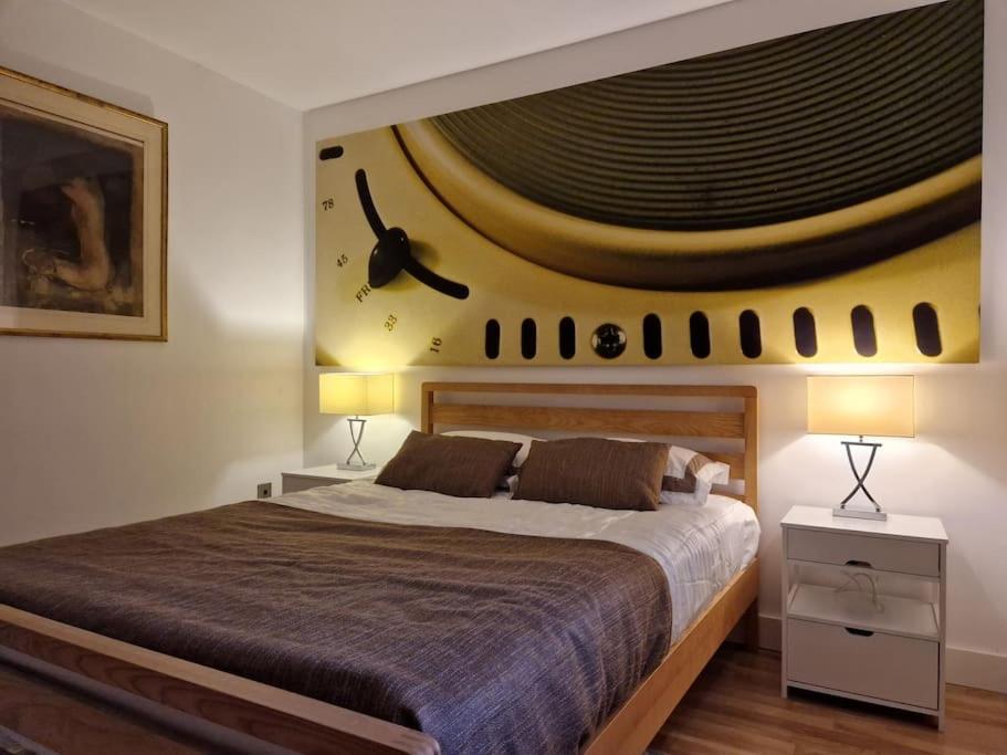 a bedroom with a large bed with a painting on the wall at Lovely London on a budget! in London