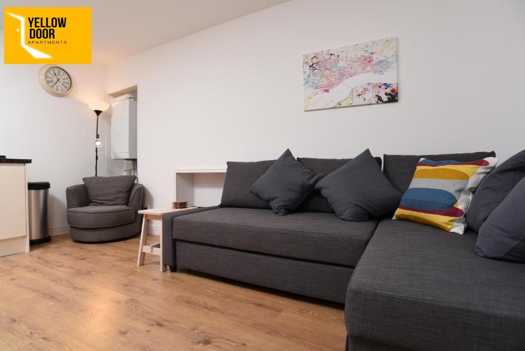 uma sala de estar com um sofá cinzento e uma cadeira em Baxter Park - City Base em Dundee