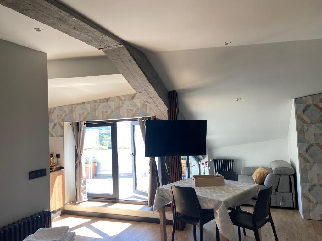 a dining room with a table with chairs and a tv at Siente Muralla in Lugo