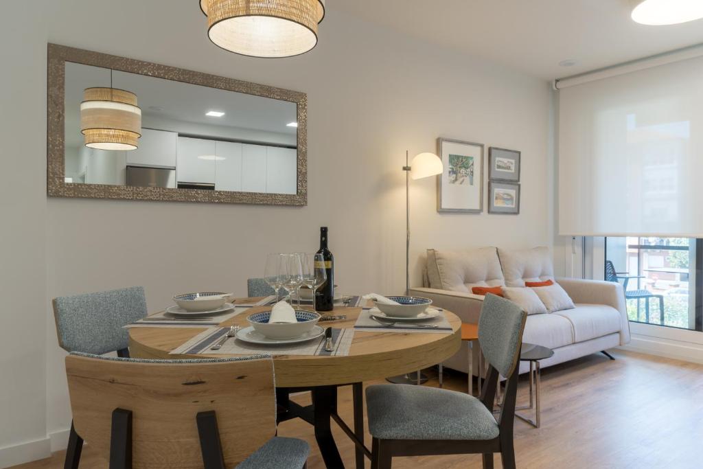 a dining room with a table and chairs and a couch at BILBAO COSTA-Algorta-Getxo- A ESTRENAR-parking-playa-metro-BILBAO en metro, a 25 mimutos in Getxo