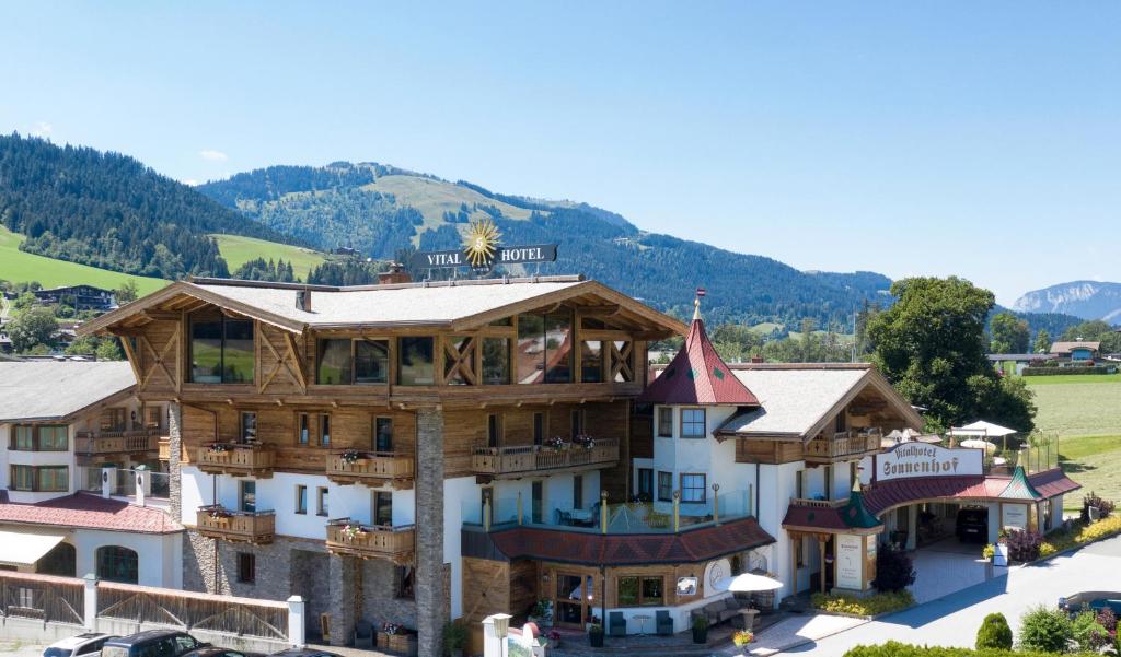 eine Luftansicht einer Lodge mit Bergen im Hintergrund in der Unterkunft Hotel Sonnenhof in Going