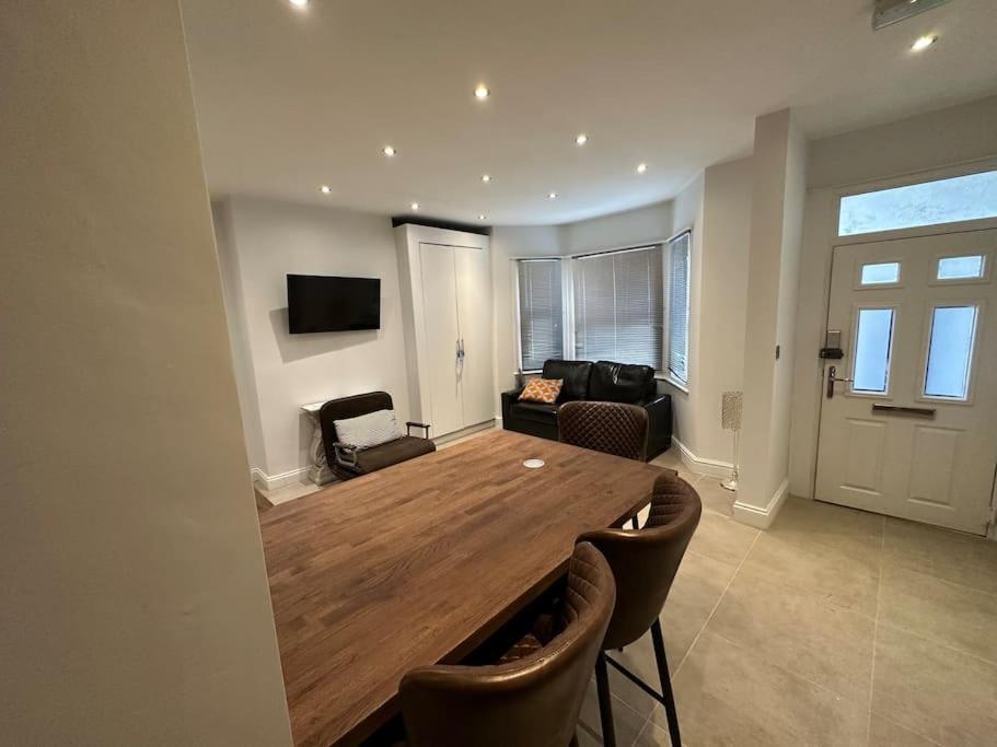 uma sala de estar com uma grande mesa de madeira e cadeiras em Stunning 2 bedroom let’s BBQ. em Brighton & Hove