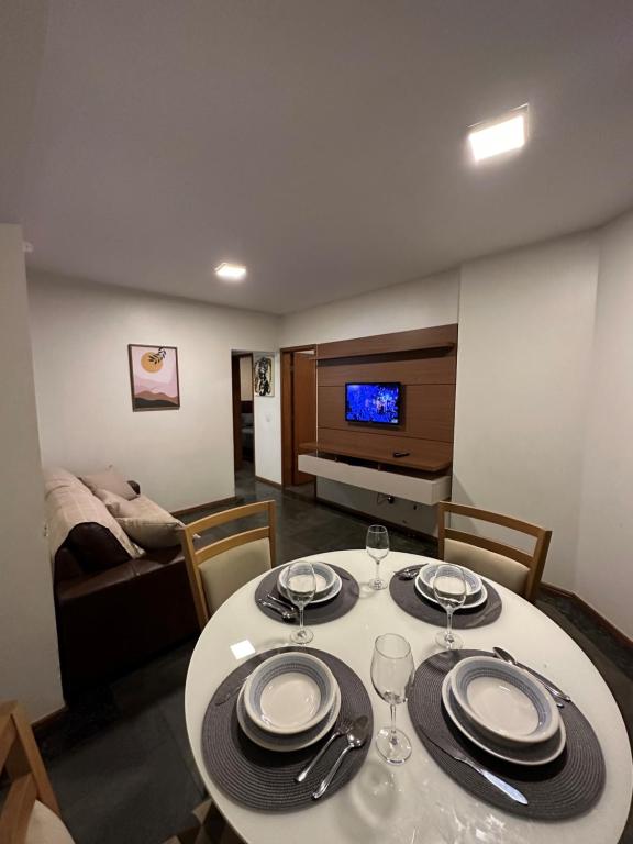 uma sala de jantar com uma mesa com pratos e copos de vinho em Apartamento no Setor Bueno - imóvel completo e com excelente localização em Goiânia
