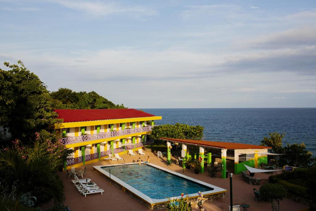 a hotel with a swimming pool next to the ocean at Galina Breeze in Port Maria