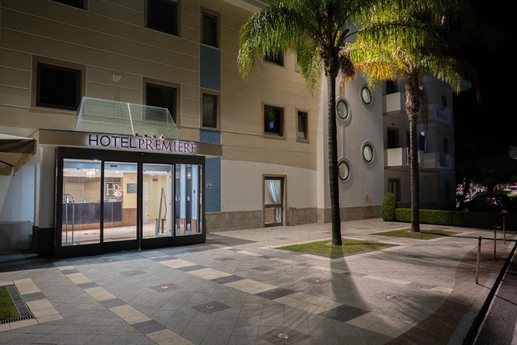 a hotel entrance with a palm tree in front of a building at Hotel Premiere in Marina di Varcaturo