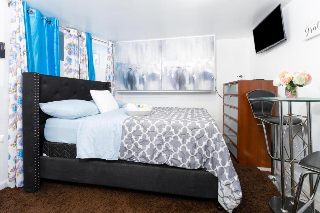 Schlafzimmer mit einem Bett, einem Tisch und einem TV in der Unterkunft Exquisite in Brooklyn