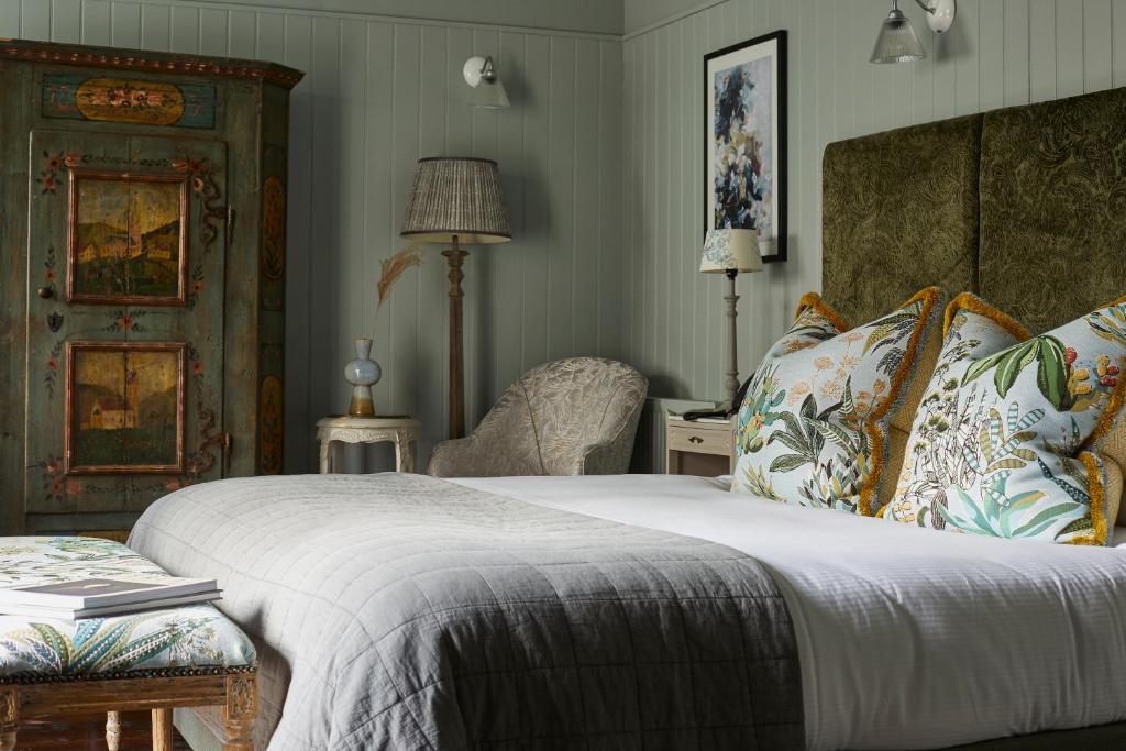 1 dormitorio con 1 cama grande y 1 silla en The King's Arms, en Dorchester