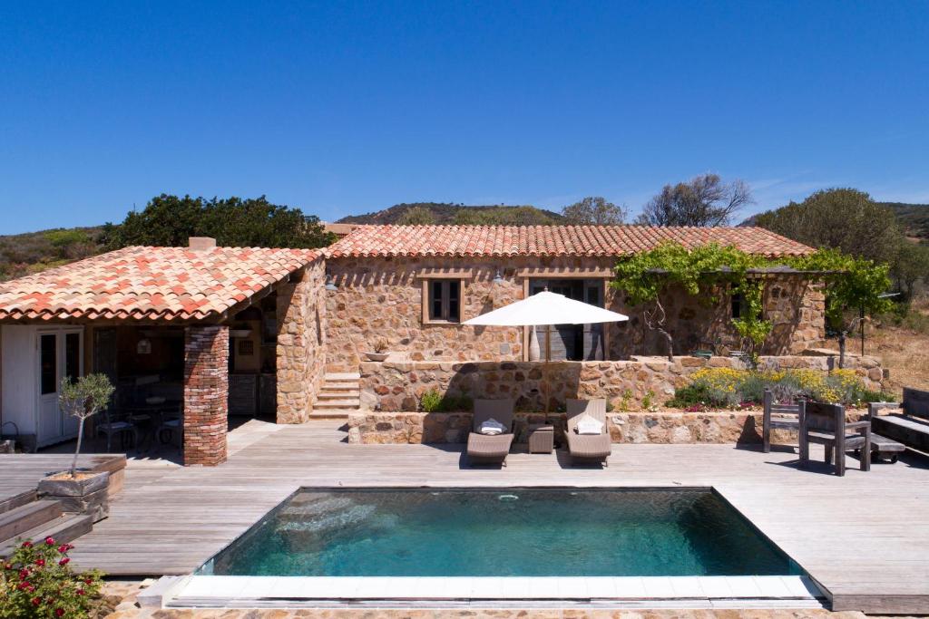 a villa with a swimming pool in front of a house at Les Bergeries d'Arone in Piana