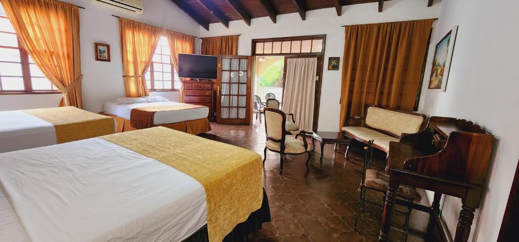Camila´s Hotel في سان بيدرو سولا: غرفه فندقيه سريرين وتلفزيون