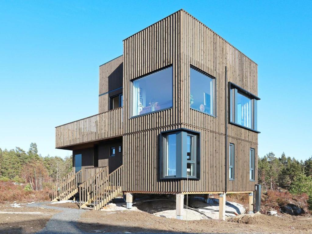 ein Holzhaus mit Glasfenstern auf einem Hügel in der Unterkunft Holiday home Søndeled in Søndeled