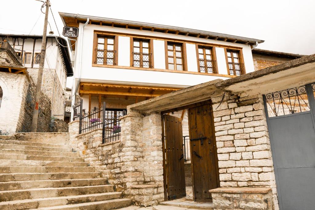 een gebouw met een deur en een trap ervoor bij Porta7 Hotel in Gjirokastër