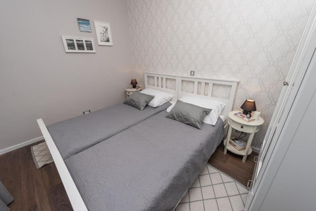 a bedroom with a large bed with two pillows at Sunset Beach Apartment in Zadar
