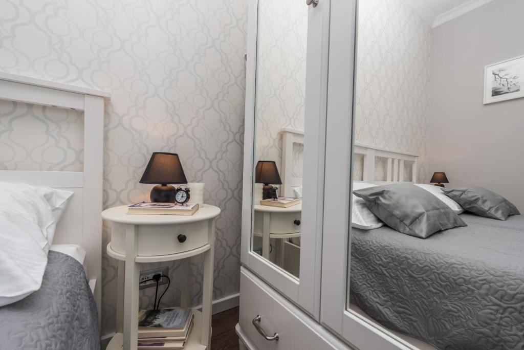 a bedroom with a mirror and a bed and a table at Sunset Beach Apartment in Zadar
