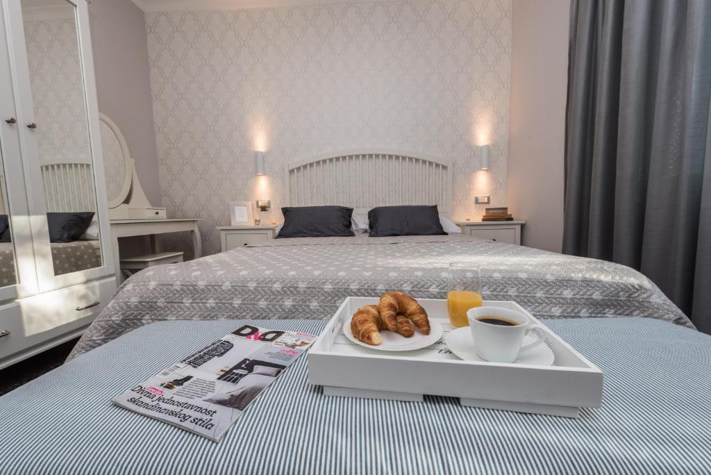 a tray with croissants and a cup of coffee on a bed at Sunset Beach Apartment in Zadar