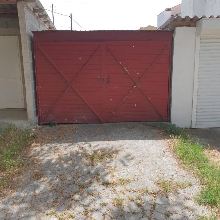 a red garage door in front of a house at Sunset Beach Apartment in Zadar