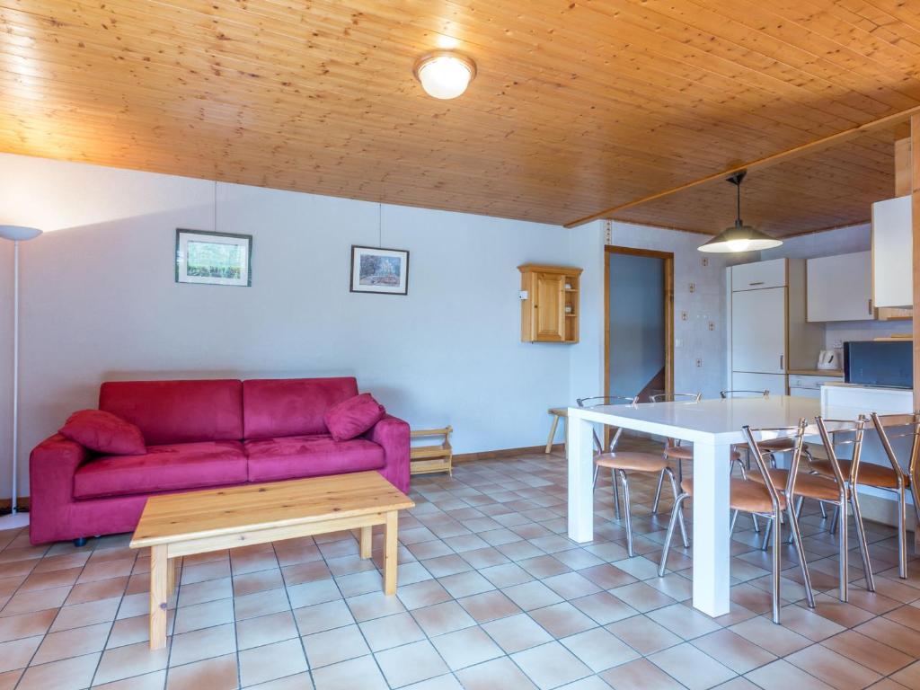 un salon avec un canapé rouge et une table dans l'établissement Rez-de-chalet avec terrasse plein Sud, sur les pistes de ski de fond – 6 pers, La Clusaz - FR-1-437-29, à La Clusaz