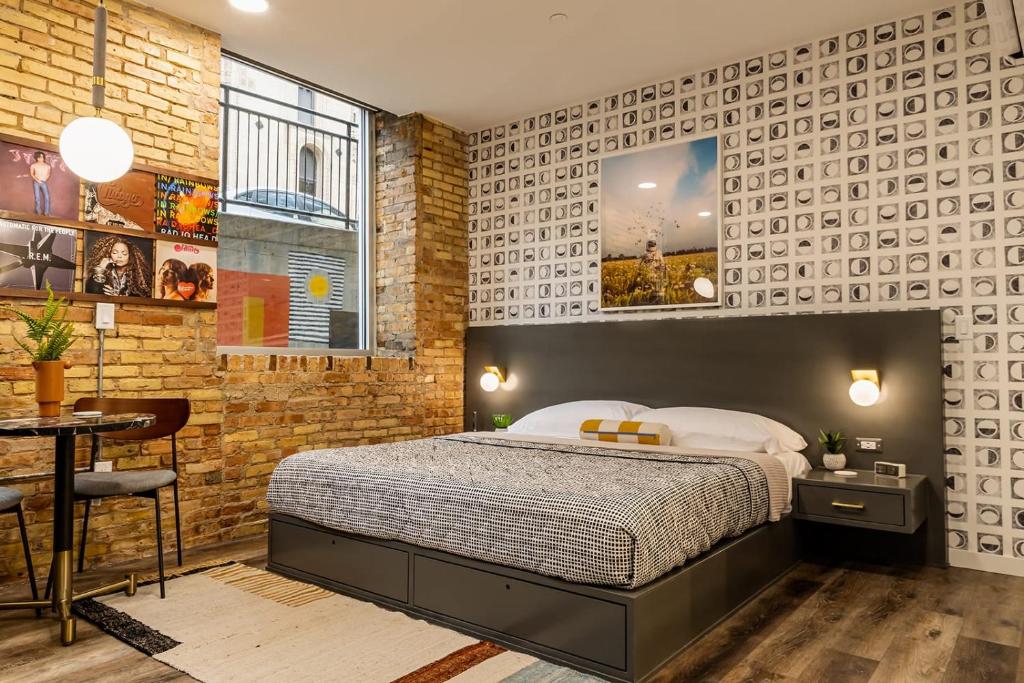 a bedroom with a bed and a brick wall at The Finnley Hotel in Grand Rapids