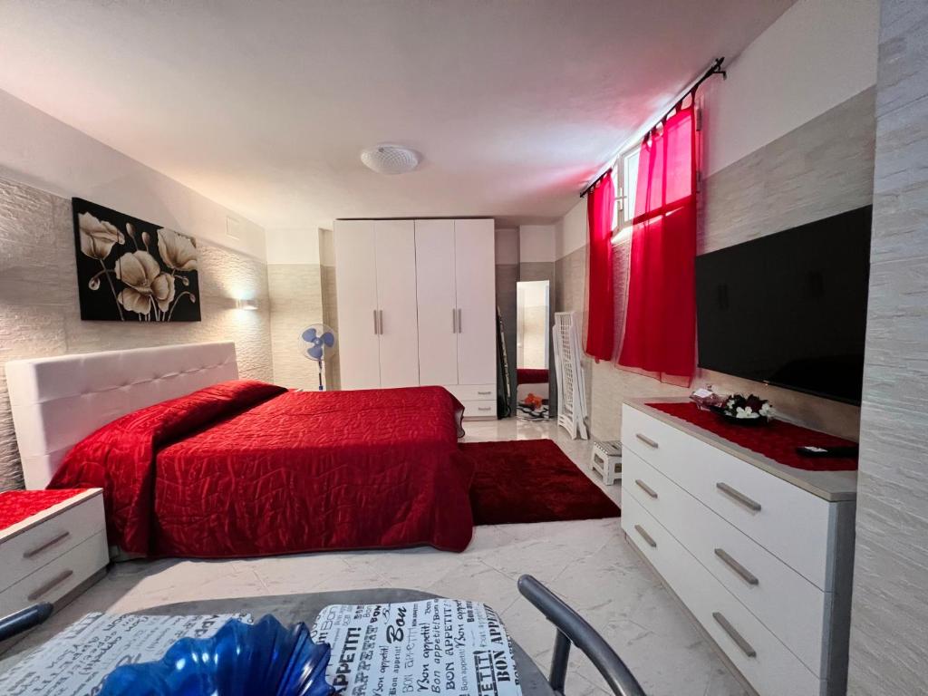 1 dormitorio con cama roja y TV en Tropea Comfort Room en Tropea