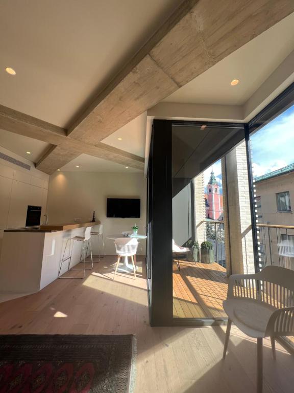 a kitchen and living room with a view of a balcony at Castle View Luxury Suite in Ljubljana