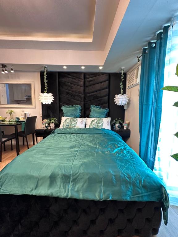 a bedroom with a large bed with a wooden headboard at Queen Size Studio in Solinea, Cebu City in Cebu City